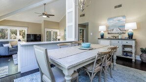 A spacious living area with a dining table, chairs, and a kitchen area with a counter and cabinets. - 1981 St Andrews: Pet Friendly 2 Beds, 2 Baths, Palmetto Dunes villa (Hilton Head Island)