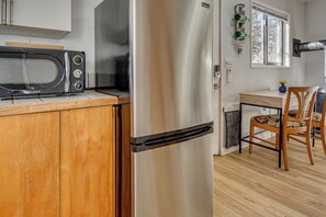 A compact kitchen with a stainless steel refrigerator, a microwave, and a wooden countertop. - Walk to Dtwn Ashland! Couple's Retreat w/ Yard (Ashland)