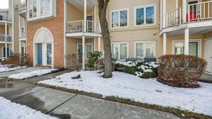 A multi-story residential building with a brick facade, multiple balconies, and a snow-covered ground. - Easy Commute to Philly: Traveling Pros' Hub! (Levittown)