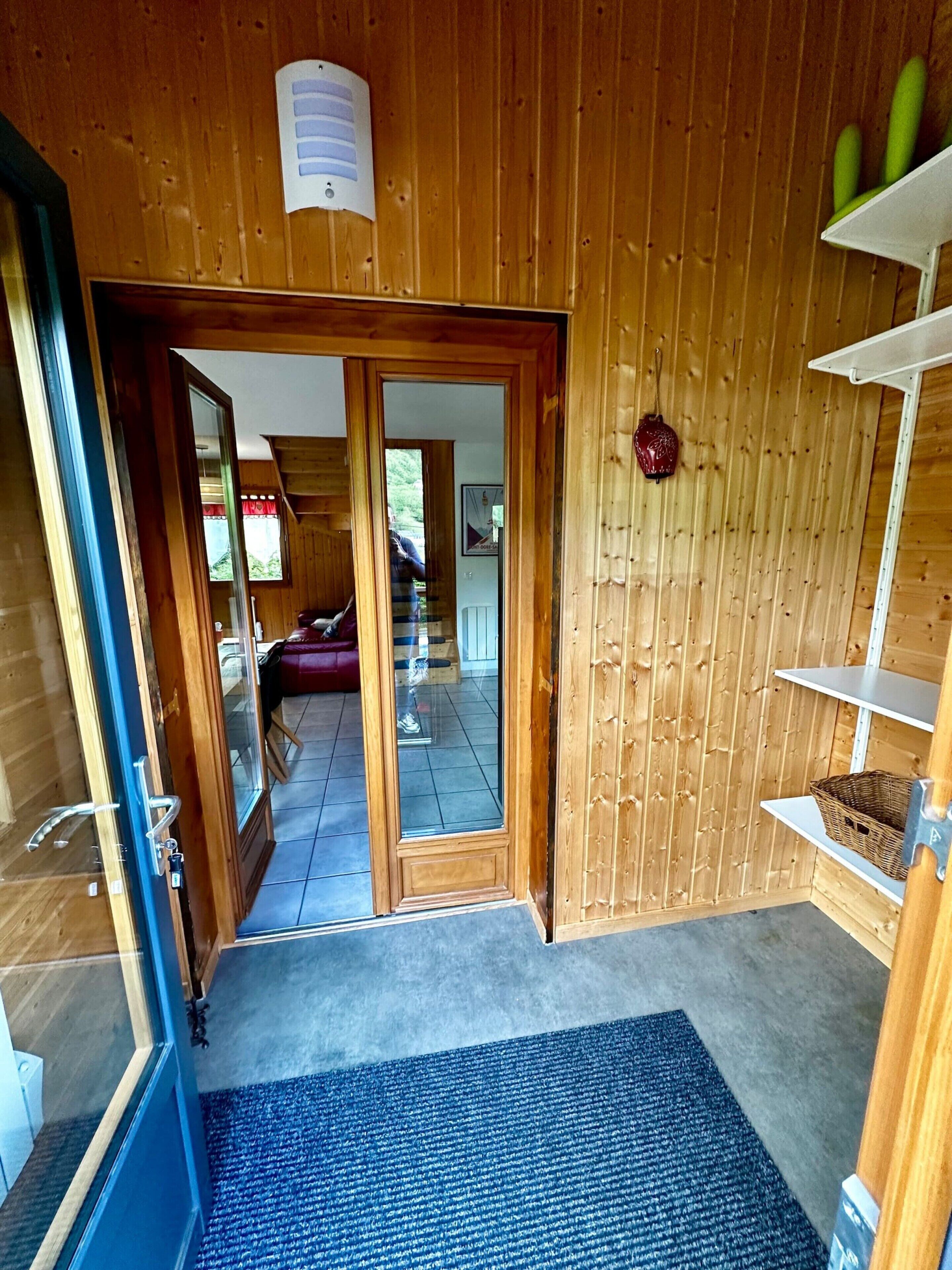 A wooden interior with a glass door leading to a balcony.