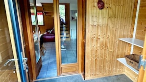 A wooden interior with a glass door leading to a balcony. - Spacious French Chalet Stay for 10 (Mont-Dore)