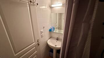 A bathroom with a white sink, a mirror, and a towel rack.