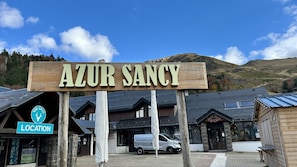A wooden sign with "AZUR SANCY" written on it, indicating the location. - Stay by the Hiking Trails (Mont-Dore)