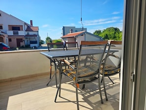 A balcony with a table and chairs, a view of houses, and a clear sky. - Costal Apartment for 4 in Zaton (Nin)
