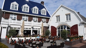 Un bâtiment européen traditionnel, avec un toit recouvert de tuiles bleues et une façade blanche.