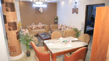 A living room with a dining table, chairs, sofas, and a coffee table.