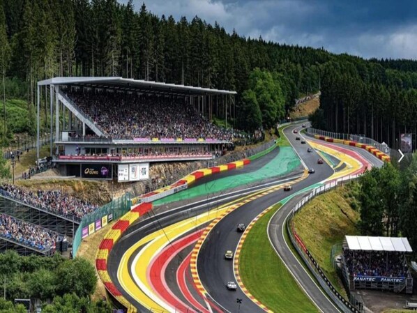Une piste de course dotée de plusieurs voies et d’une tribune remplie de spectateurs.