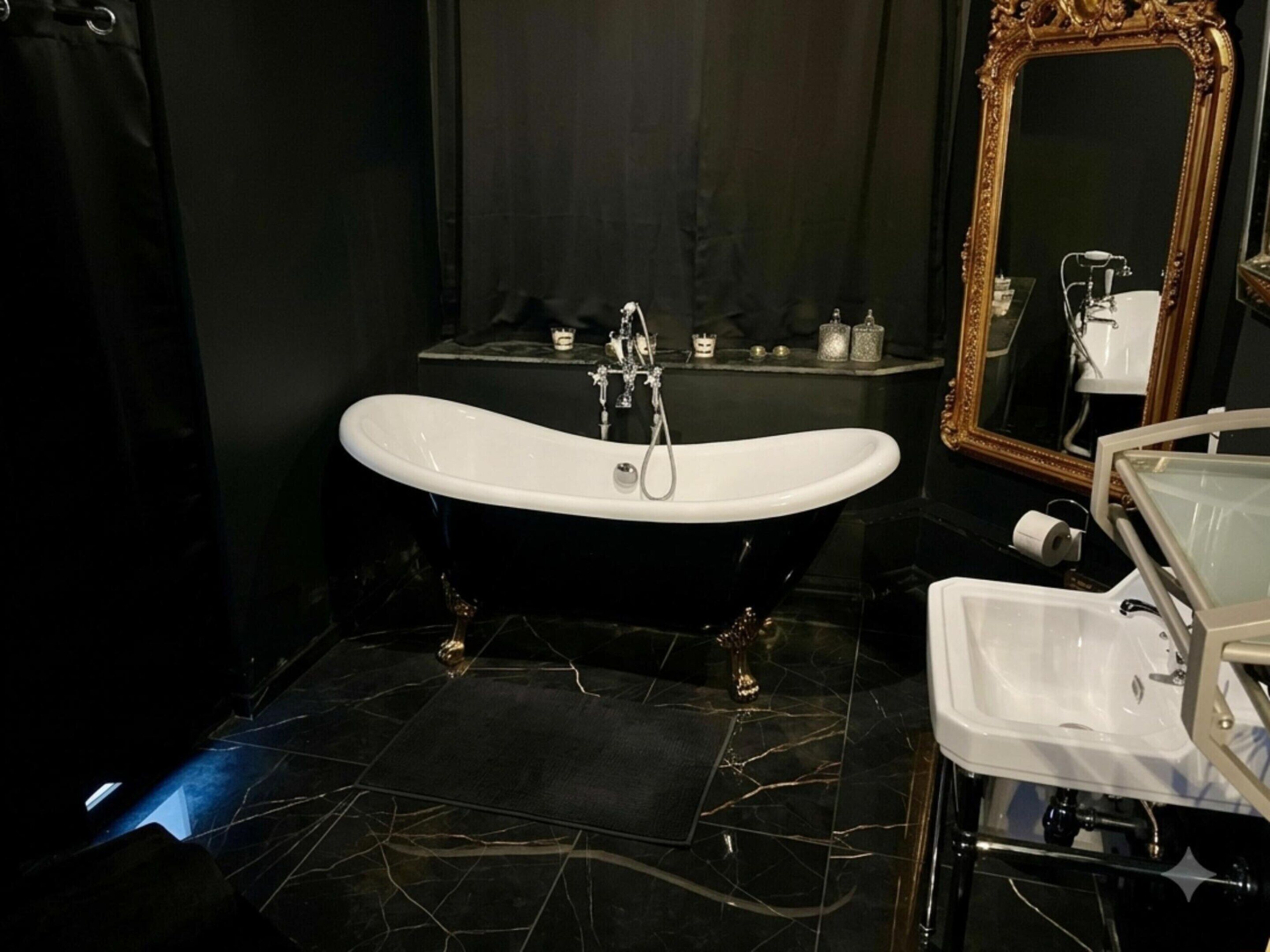 A bathroom with a freestanding bathtub, a vanity with a sink, and a mirror.