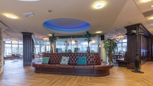A spacious lobby with a leather sofa, wooden flooring, and a blue accent on the ceiling. - Scenic Escape with Complimentary Breakfast, Parking and Local Trails (Middelburg)