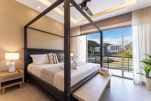 A four-poster bed with a view of the city through large windows. - 2BR Condo Steps to Beach | Costta A Santa Cruz (Huatulco)