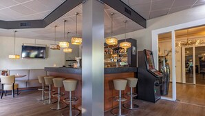 Een bar met verschillende krukken, een toonbank en een aan de muur bevestigde televisie.