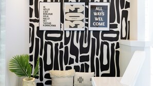 A wall with three framed signs, a potted plant, and a cushion. - Global Retreat in the Rockies | Central Location (Denver)