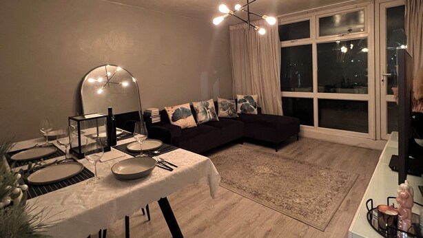 A modern living room with a dining area, a large window, and a contemporary light fixture. - Lovely 2 bedrom in Vauxhall Central London (London)