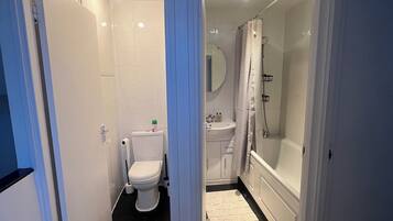 A bathroom with a toilet, sink, and bathtub.