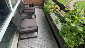 A balcony with a brick wall, a window, and a seating area with a table and chairs. - Lovely 2 bedrom in Vauxhall Central London (London)