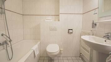 Une salle de bain avec une baignoire, des toilettes et un lavabo.