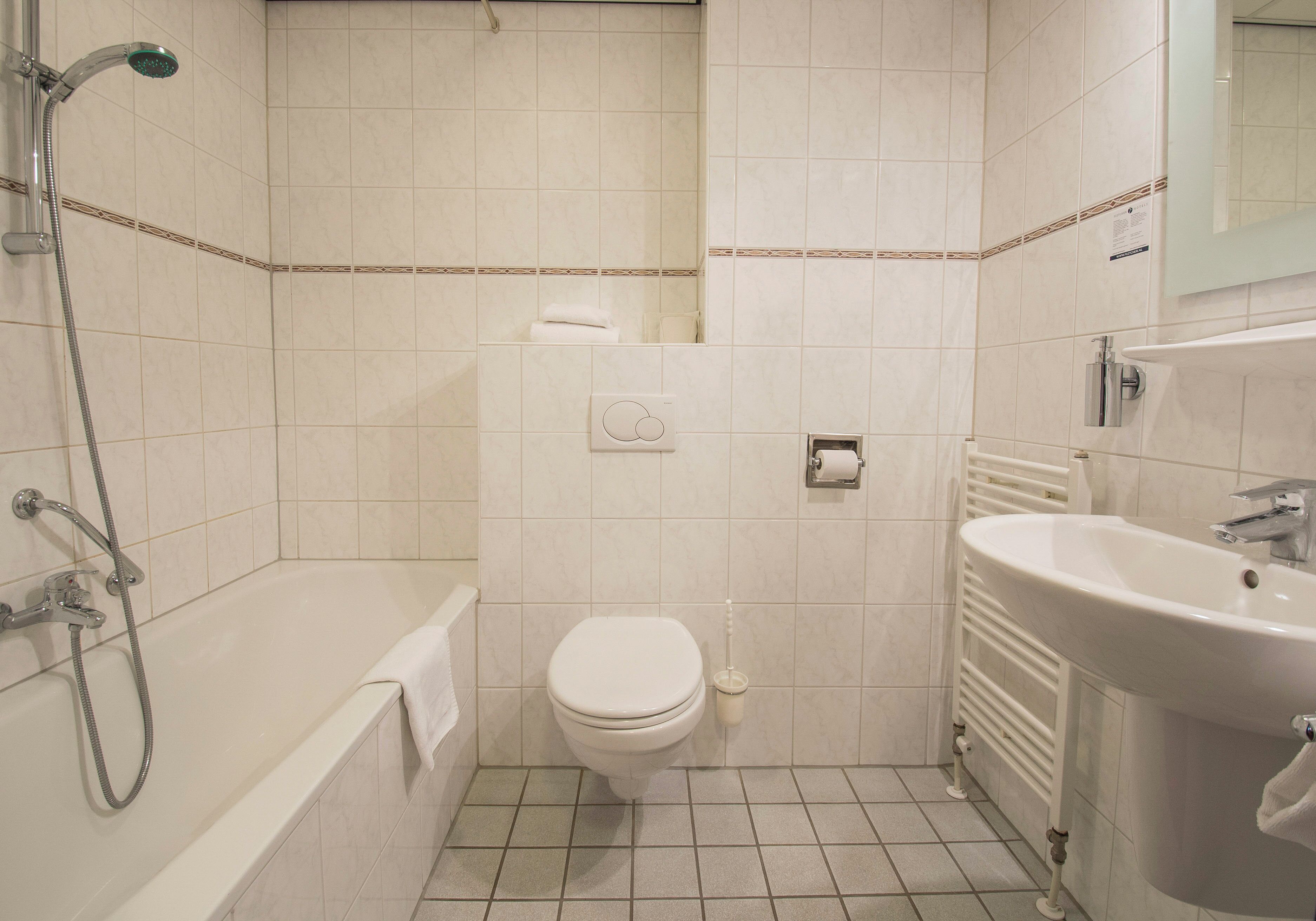 A bathroom with a bathtub, toilet, and sink.
