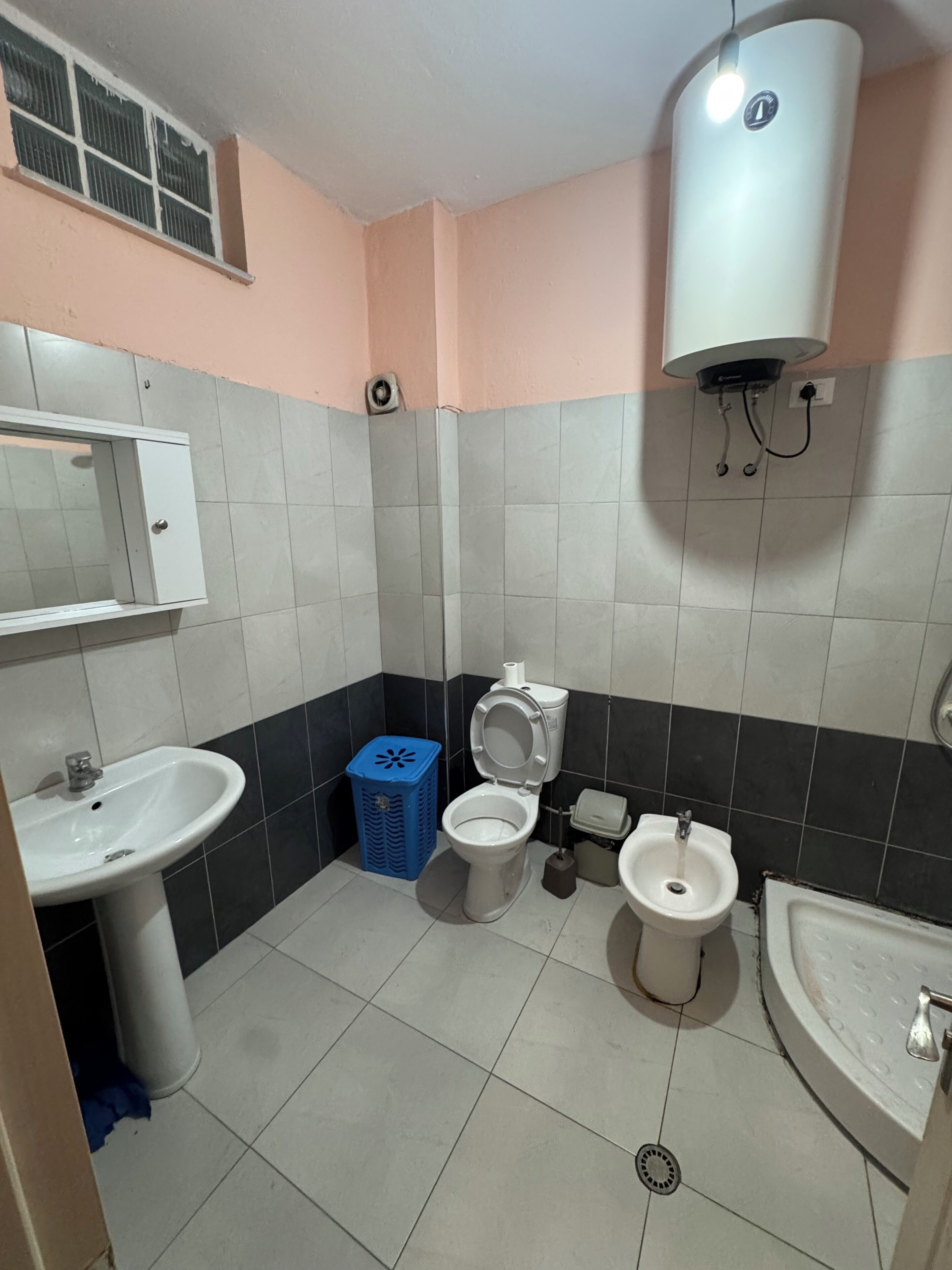 Une petite salle de bain comprenant des toilettes, un bidet, un lavabo et une poubelle.