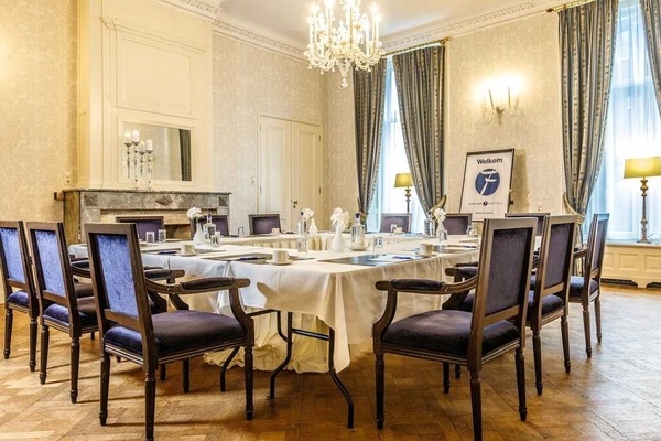 Host elegant dinners beneath a sparkling chandelier and tall drapes.
