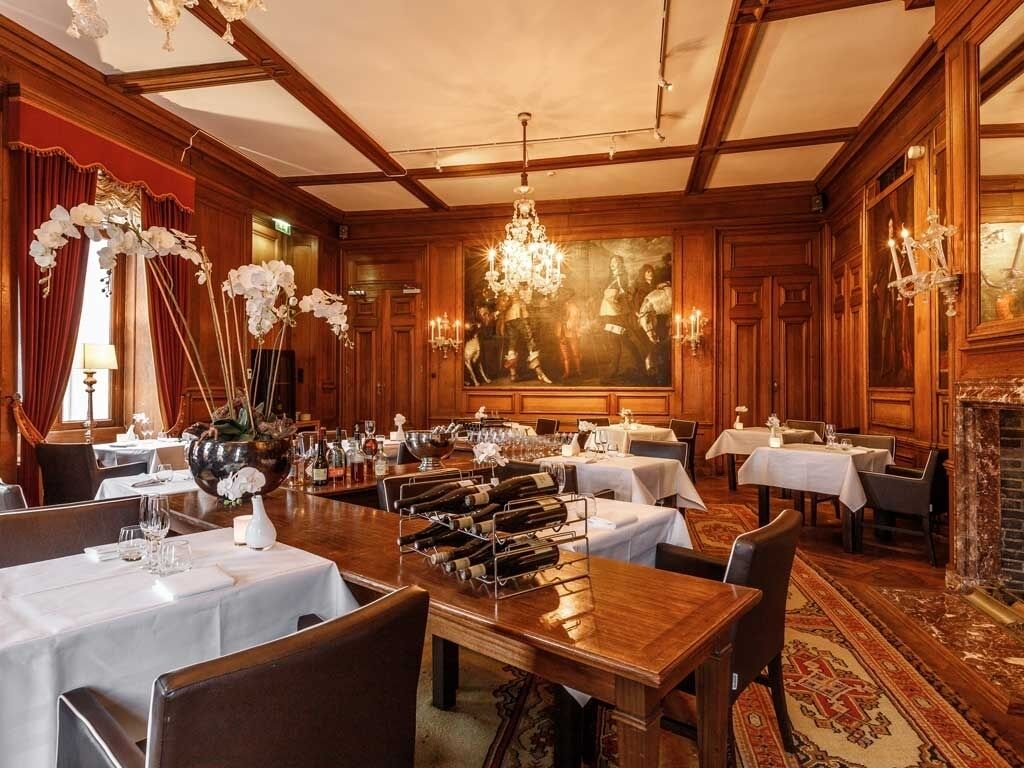 Dine by chandeliers in a richly paneled, intimate setting