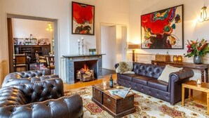 A living room with a fireplace, leather sofa, and a coffee table. - Relax in Historic Luxury with Garden Dining, Near Galleries and Oldehove (Leeuwarden)