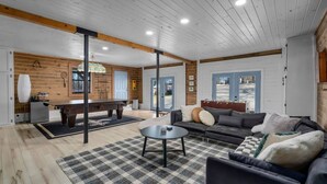 A spacious living area with a pool table, sofa, and a checkered rug. - Best Lakeside Living at Big Bend Retreat! (Houston)