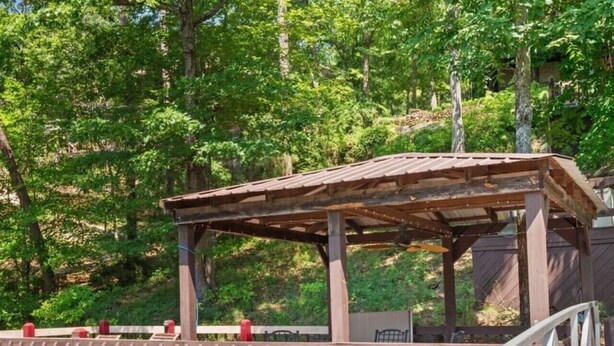 A wooden deck with a pergola, surrounded by greenery. - Best Lakeside Living at Big Bend Retreat! (Houston)