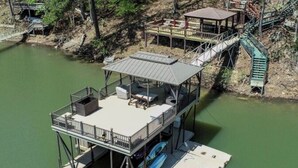 A multi-level dock with a covered seating area and a staircase connecting to a platform. - Best Lakeside Living at Big Bend Retreat! (Houston)