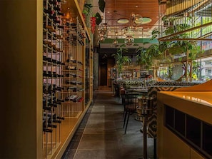 A wine cellar with racks of wine bottles, a bar area with seating, and hanging plants. - Art-Inspired Boutique Hotel Room in Central Rotterdam Near Restaurants & Shops (Rotterdam)