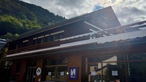 Ein Gebäude mit Netski-Beschilderung, großen Fenstern und Bergblick.