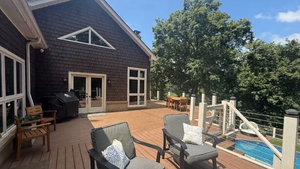 Una terrazza con mobili da esterno, un barbecue e una piscina.