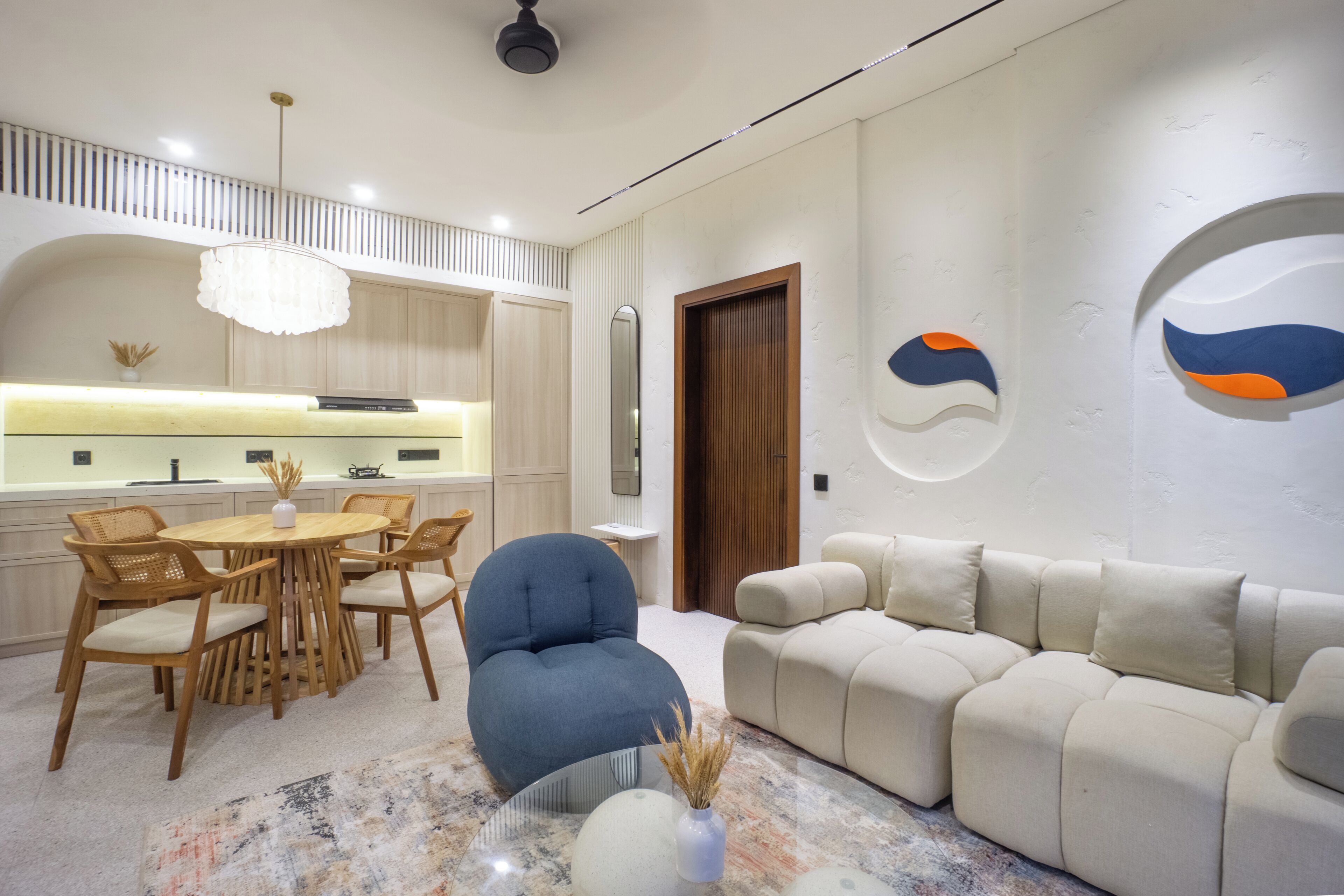 A modern interior with a dining area, sofa, and decorative wall art.