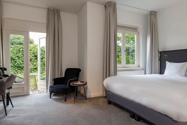 Unwind in a serene bedroom with leafy views and soft carpets.