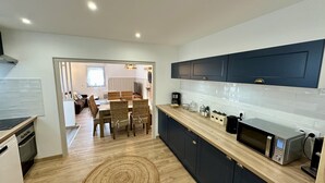 A modern kitchen with dark blue cabinets, a wooden countertop, and a microwave. - Retreat With Terrace, Parking (Mont-Dore)