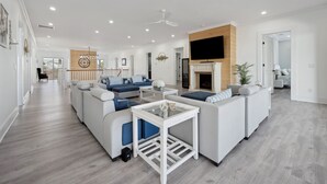 A modern living room with a sectional sofa, a coffee table, and a fireplace. - Blue Southern Charm 7 Bedroom Home (Georgetown)