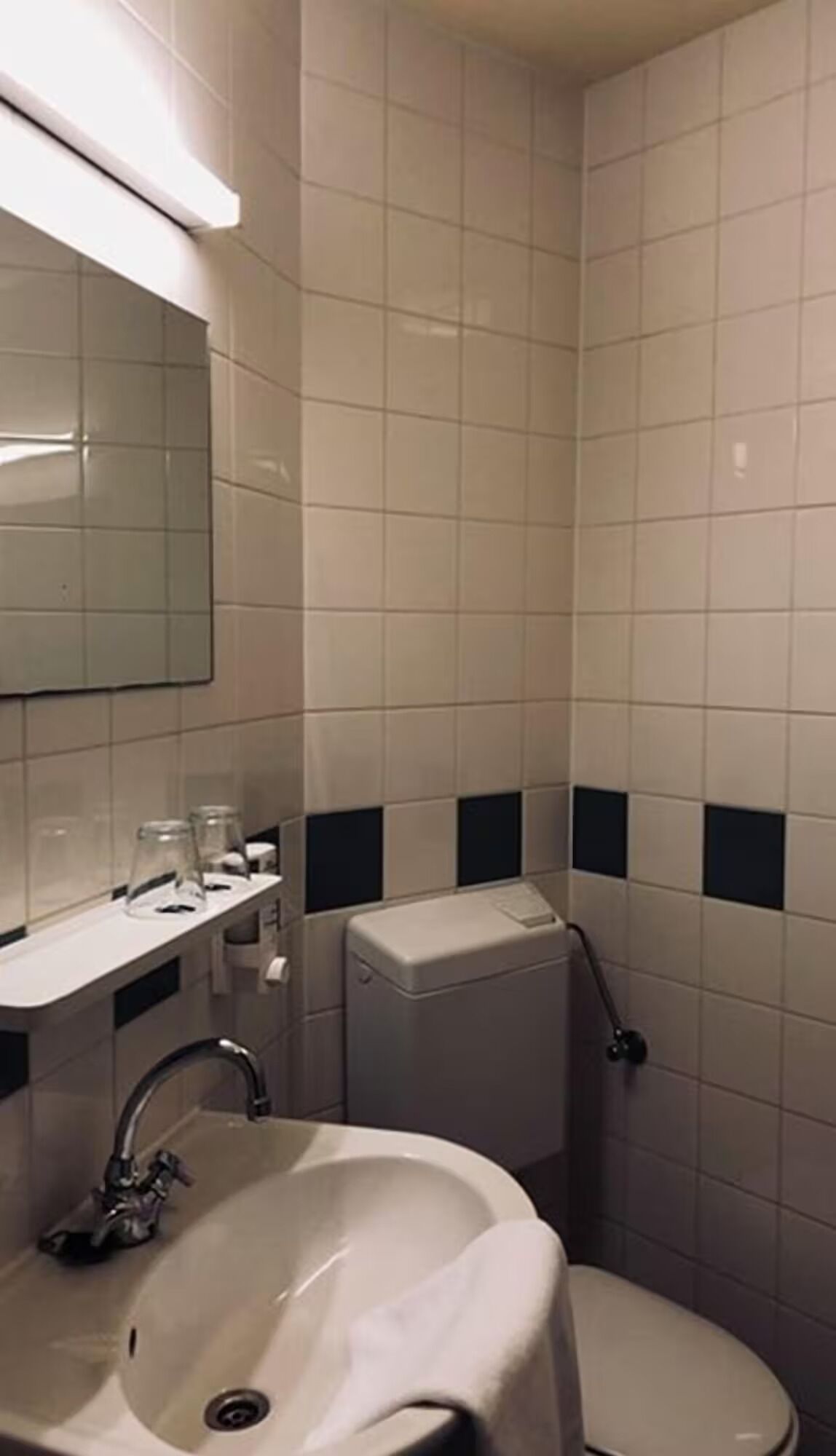 A bathroom with a sink, mirror, and toilet.