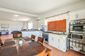 A modern kitchen with white cabinets, a stove, microwave, and a coffee station. - Casa Sonora – Near Beach, Sleeps 8, Rocky Point (Puerto Peñasco)