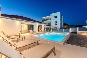 Ein moderner Poolbereich mit Liegestühlen und Schwimmbecken.