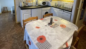 A compact kitchen with white cabinets, a microwave, a toaster, and a sink. - Bright Apartment in Mont-dore (Mont-Dore)