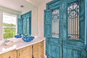 Una cocina con armarios color turquesa, una ventana con vistas y una encimera con un tazón azul.