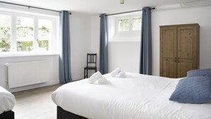 A hotel room with a large bed, a wooden wardrobe, and a window with curtains. - La Bourboule Quiet Villa or 5 (La Bourboule)