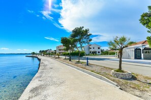 A coastal road with houses, a clear blue sky, and a calm sea. - Beachfront Apartment for 4 (Vir)