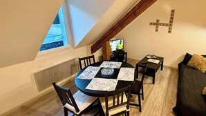 Comedor con una mesa redonda, sillas y un televisor.