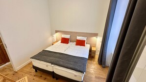 A small, neatly arranged bedroom with a bed, bedside tables, and a nightstand. - Nature Refuge Near the Trail (Mont-Dore)