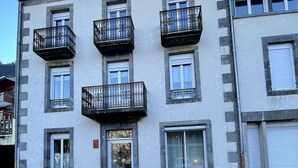 Un edificio de varios pisos con balcones, una puerta y ventanas.