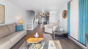 Ein modernes Wohnzimmer mit Sofa, Couchtisch und einer Treppe zu einer anderen Ebene.
