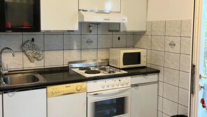 Ett kök med gasspis, mikrovågsugn, ugn och diskmaskin.
