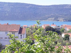 A coastal town with terracotta-roofed buildings, a clear blue sea, and hills in the background. - Apartment Moreno 2 With Seaview (Marina)