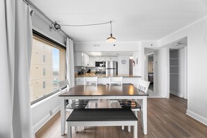 A modern kitchen with white cabinets, a stainless steel refrigerator, and a large window. - Marigot Beach 1201 Direct Oceanfront 3BR (Ocean City)