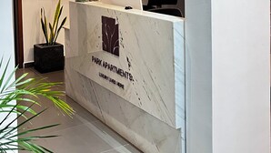 A reception desk with a marble top, a staircase, and a sign reading "CONCIERGE". - Luxury Studio Apartments in Accra  (Accra)
